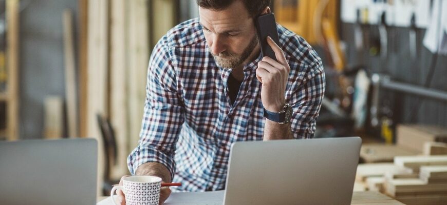 Фото мужчина на рабочем месте говорит по телефону